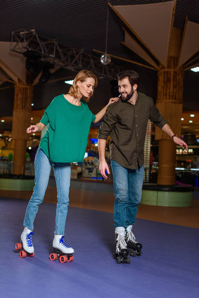young couple skating together on roller rink - Photo, Image