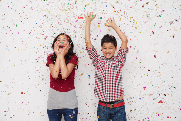 Happy excited children standing under glitter rain - 写真・画像