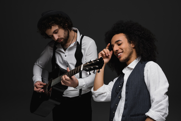 duet of musicians playing guitar and singing on black - Photo, Image