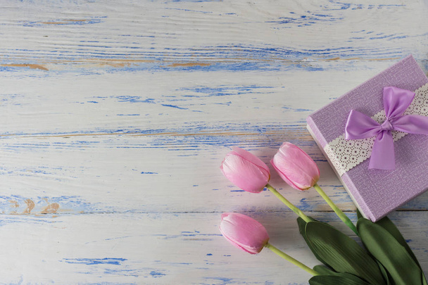 Розовые тюльпаны и подарочная коробка на белом деревянном фоне. Спак для копирования
 - Фото, изображение