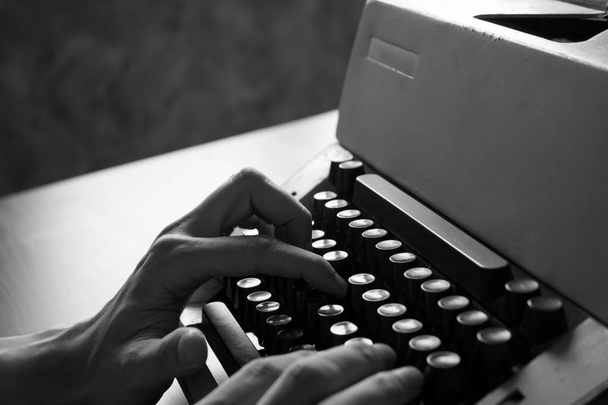Primer plano de las manos masculinas escribiendo en la vieja máquina de escribir. Tono blanco y negro
 - Foto, imagen