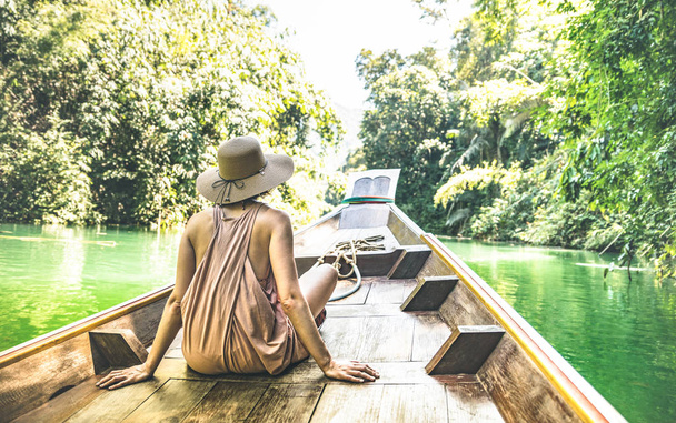 ロングテールの若い女性旅行者 Cheow Lan 湖 - ワンダー ラストでアイランドホッピングでボートツアーし、タイ - 暖かい緑フィルターの遠足旅行概念冒険少女観光放浪者と - 写真・画像