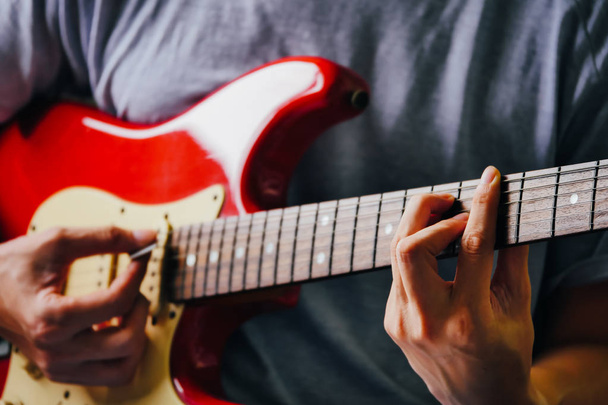 Κοντινό πλάνο της ανδρικής χέρια παίζοντας ηλεκτρική κιθάρα. Επιλεκτική εστίαση - Φωτογραφία, εικόνα