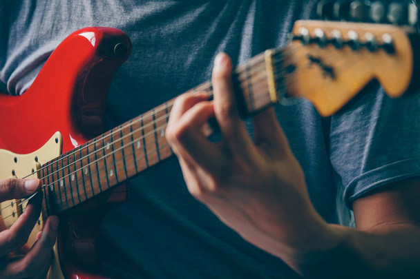 Zbliżenie na męskie ręce grać na gitarze elektrycznej. Selektywny fokus - Zdjęcie, obraz