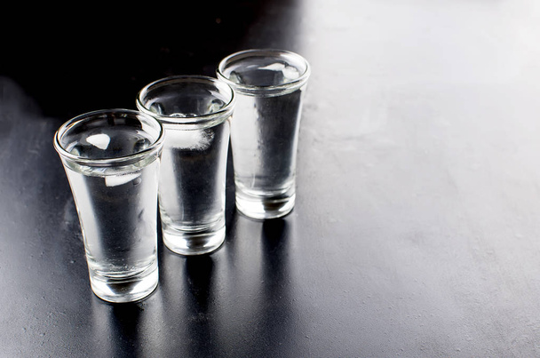 Vodka shots on black table - Fotó, kép