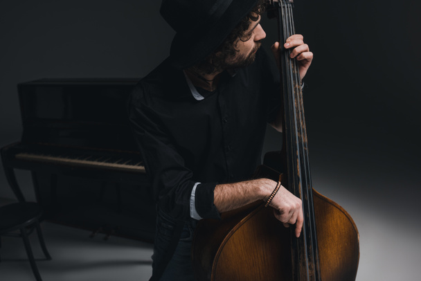 young handsome musician playing contrabass - Foto, Imagen