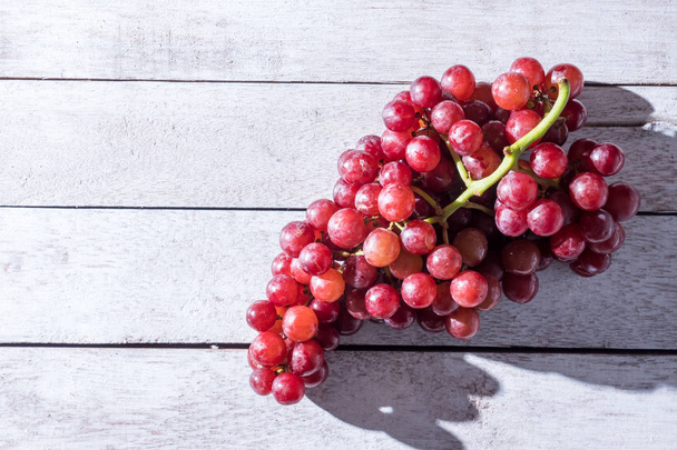 Vista superior de uvas vermelhas na mesa de madeira. Espaço livre para texto
 - Foto, Imagem