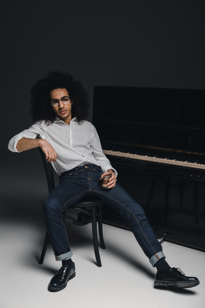 handsome stylish musician with glass of whiskey in front of piano - Photo, Image