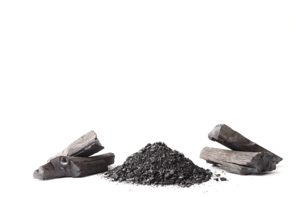 Carbón vegetal y polvo (carbón activado) sobre fondo blanco. Espacio libre para texto
 - Foto, imagen