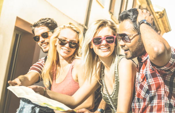 Gruppe junger Hipster-Touristen jubelt mit Stadtplan in der Altstadt - Reisekonzept mit fröhlichen Menschen, die zusammen Spaß haben - warmer heller Nachmittagsfilter mit starkem Sonnenscheinton - Foto, Bild