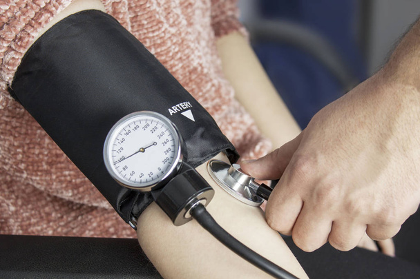Лікар приймає кров'яний тиск
 - Фото, зображення