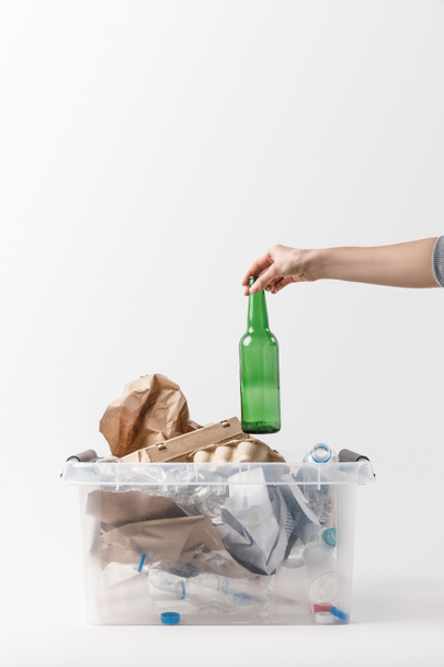 cropped shot of woman putting glass bottle into container with plastic bottles, recycle concept - Valokuva, kuva
