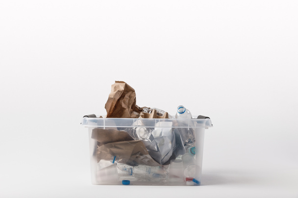 close up view of container with paper and plastic garbage isolated on white, recycling concept - Фото, зображення