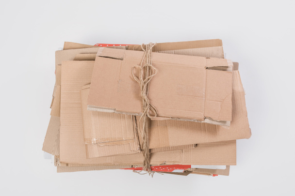 bovenaanzicht van stapel gevouwen kartonnen dozen geïsoleerd op grijs, recycle concept - Foto, afbeelding