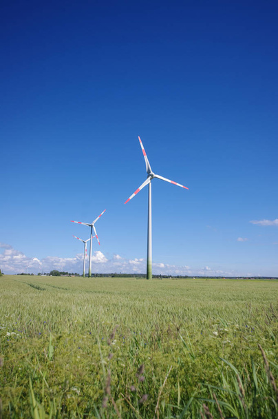 Alternatieve energie hulpbronnen generatoren - windturbines omgeven door de natuur - Foto, afbeelding