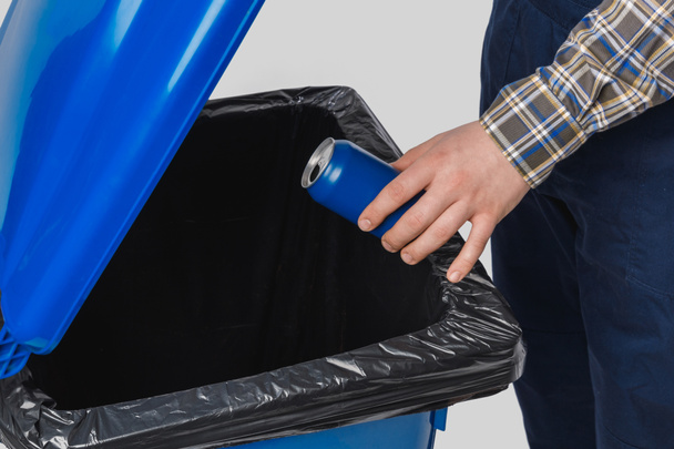 partial view of cleaner putting can into trash bin isolated on grey - Foto, imagen