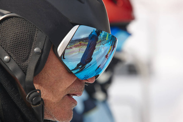 Ski goggles on a white winter landscape. Blue reflection - Photo, Image
