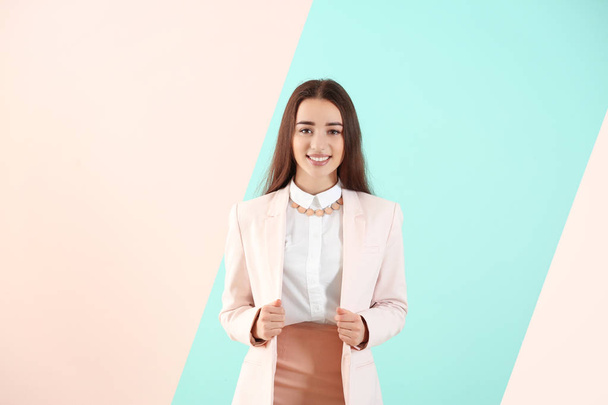 Beautiful young woman in elegant suit on color background - Foto, Imagen