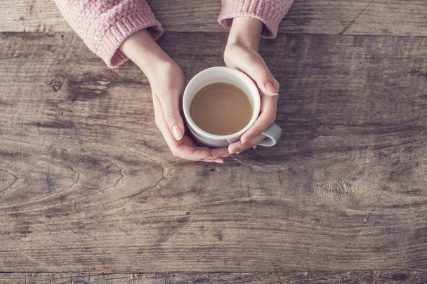 Frau hält Kaffeetasse hölzernen Hintergrund - Foto, Bild