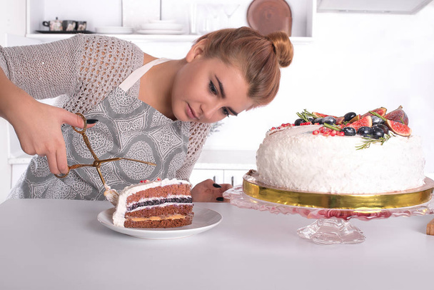 the young hostess cuts cake  - Fotoğraf, Görsel