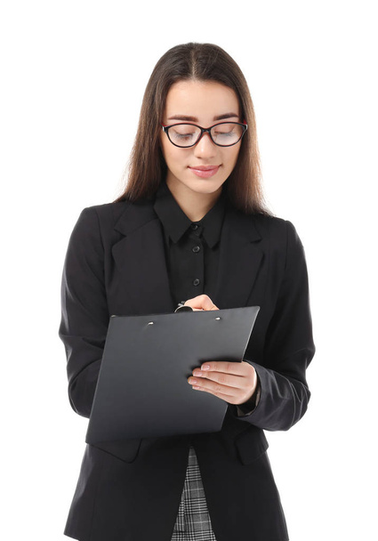 Beautiful young woman in elegant suit and with clipboard on white background - Φωτογραφία, εικόνα