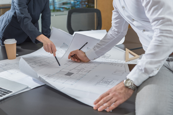 cropped shot of stylish architects working with building plans together at office - Photo, Image
