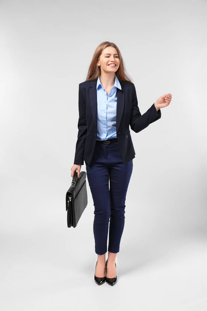 Beautiful young businesswoman in elegant suit on light background - Foto, afbeelding