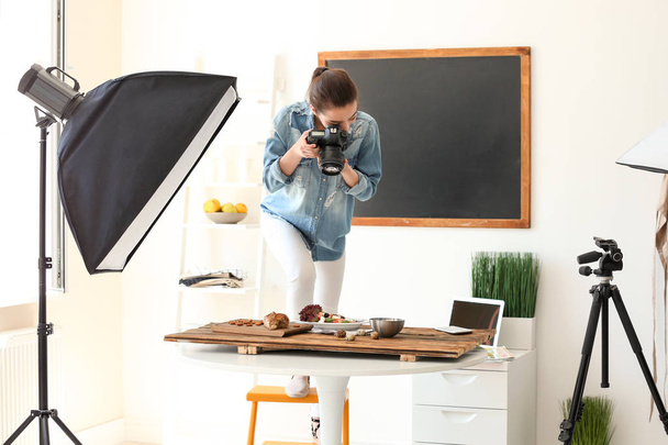 Mladá žena s profesionálním fotoaparátem fotit zátiší v ateliéru - Fotografie, Obrázek