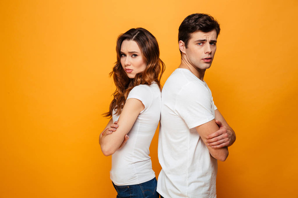 Confused young couple standing with one another's back - Zdjęcie, obraz
