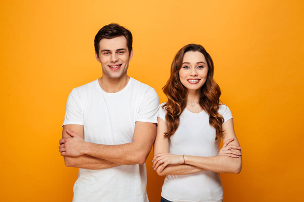 Portrait of a happy young couple standing with arms folded - Foto, Imagem
