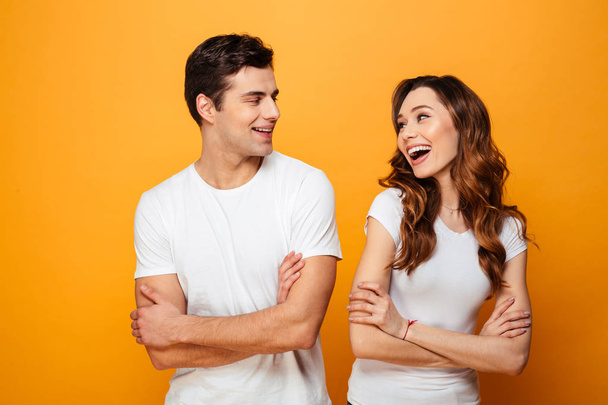 Portrait of a cheerful young couple standing with arms folded - Foto, afbeelding