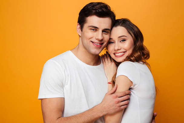 Portrait of young man and woman in white t-shirts smiling and po - Foto, immagini