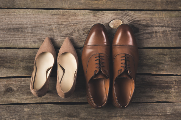 top view of bridal and grooms pairs of shoes on wooden surface - Photo, Image