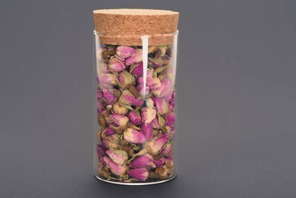 крупным планом вид красивых сухих бутонов роз в стеклянной банке, изолированных на сером
  - Фото, изображение