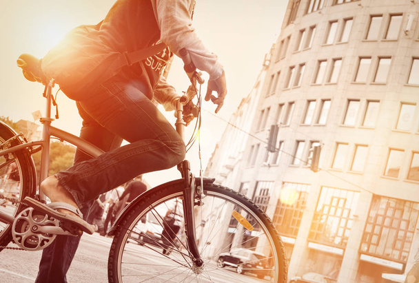 Hombre en bicicleta en el tráfico con el sol
  - Foto, Imagen
