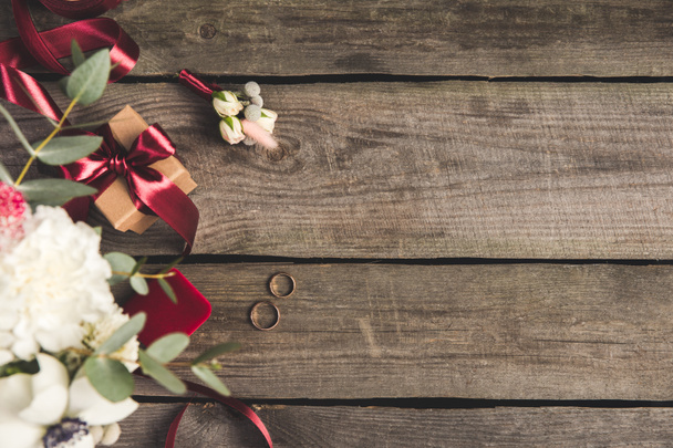 flat lay com anéis de casamento, caixa de jóias, buquê de noiva e corso na mesa de madeira
 - Foto, Imagem