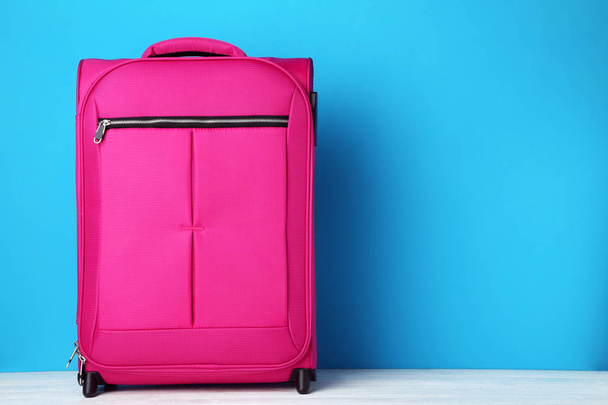 Pink suitcase on blue background - Foto, imagen