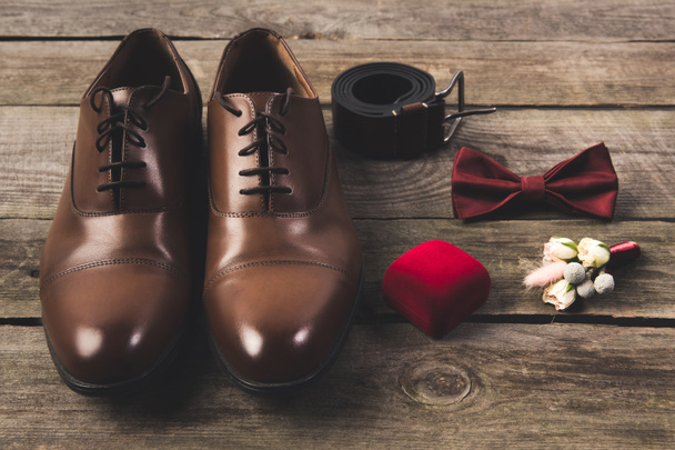 vista de perto dos noivos dispostos sapatos e acessórios na superfície de madeira
 - Foto, Imagem