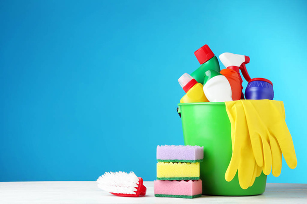 Garrafas com detergente e ferramentas de limpeza em fundo azul
 - Foto, Imagem