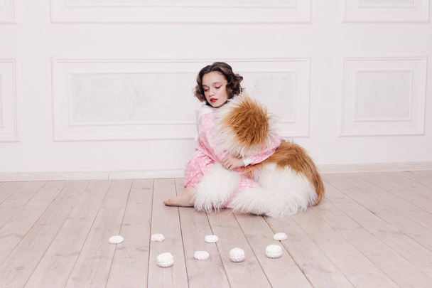 Cute little girl in pajama with sweets sitting on the floor - Valokuva, kuva