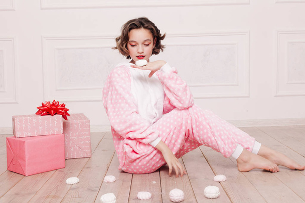 Cute little girl in pajama with sweets sitting on the floor - Foto, Imagem