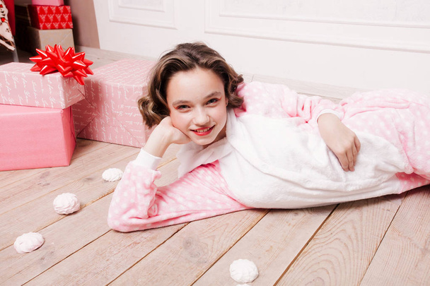Cute little girl in pajama with sweets sitting on the floor - Photo, image