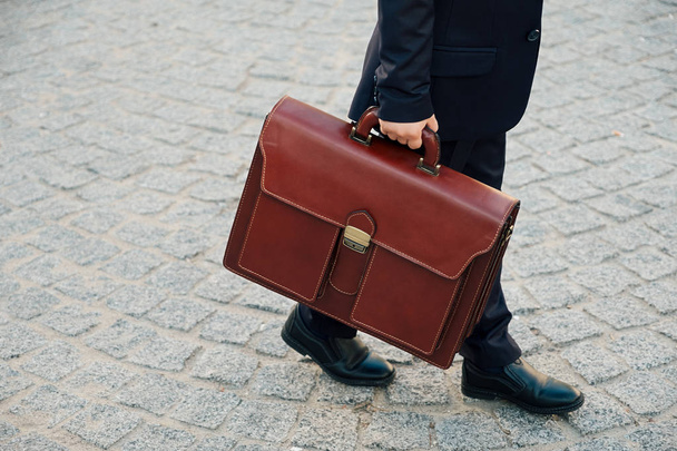 Hand holding business leather braun briefcase  - Valokuva, kuva