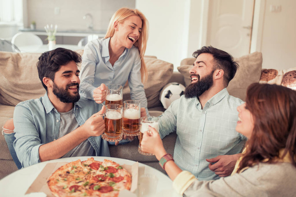 Happy vrienden eten van pizza en tv kijken thuis. Mensen, eten, plezier en geluk concept. - Foto, afbeelding