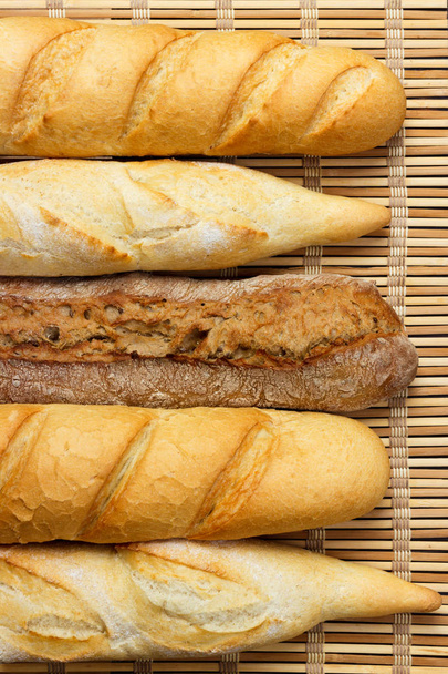 Ahşap bir masa üzerinde taze Fransız baget ekmek çeşitleri - Fotoğraf, Görsel