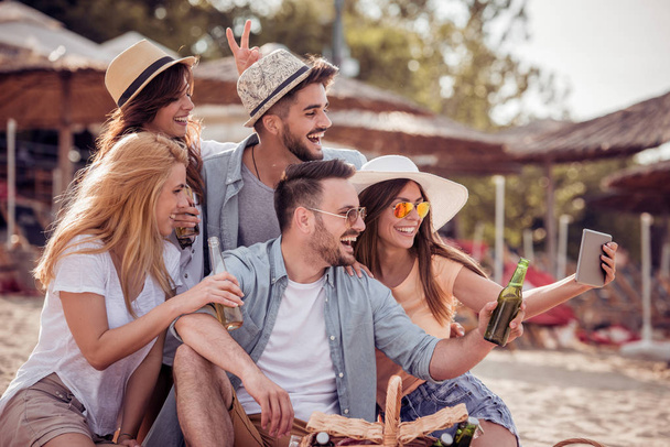 Kesälomat, loma, onnellinen ja ihmiset käsite-ryhmä ystäviä ottaa selfie tabletilla rannalla
. - Valokuva, kuva