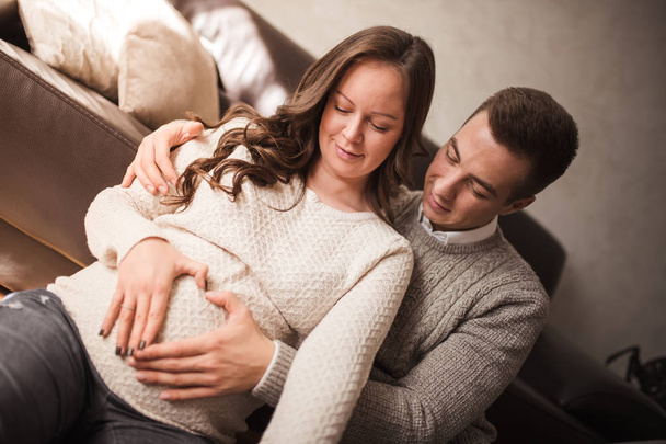 Těhotná žena s manželem doma. Pojem rodina, láska a štěstí. - Fotografie, Obrázek