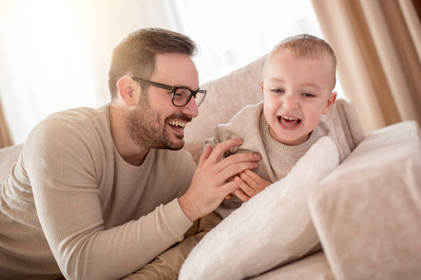 Father and son smiling while spending time together at home. - Photo, Image