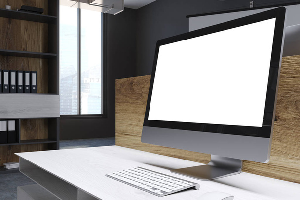 Blank computer screen in a wooden office - 写真・画像