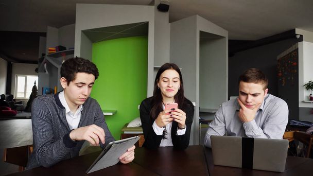 Tres colegas, mujeres y dos jóvenes se sientan en la red social
 - Foto, Imagen